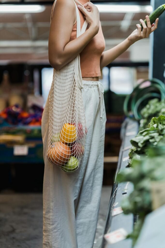 A shopper carrying reusable bags filled with eco-friendly products, symbolizing the environmental impact and sustainability of consumerism.